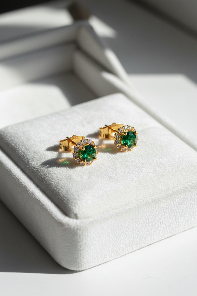 Élan emerald halo stud earrings on white velvet jewelry tray