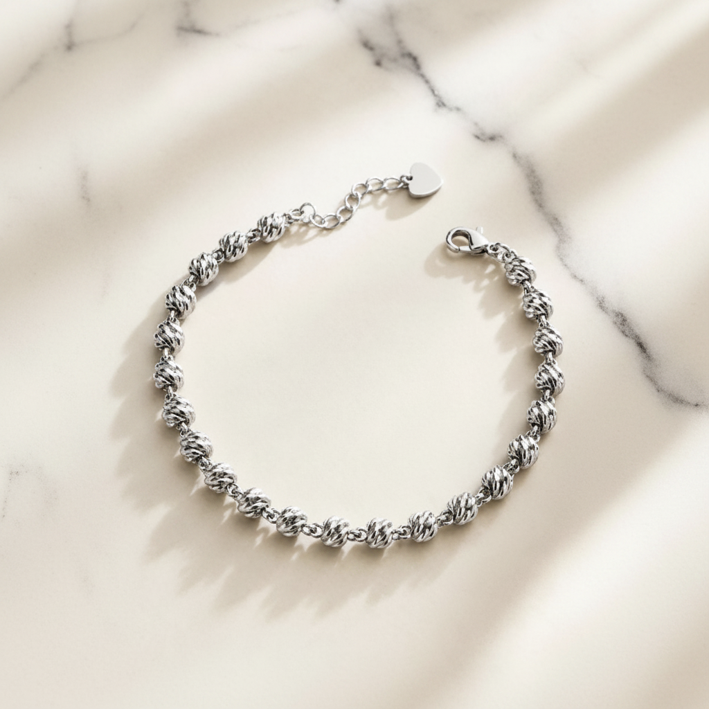 Charleston white gold twisted ball chain bracelet flat lay on white marble