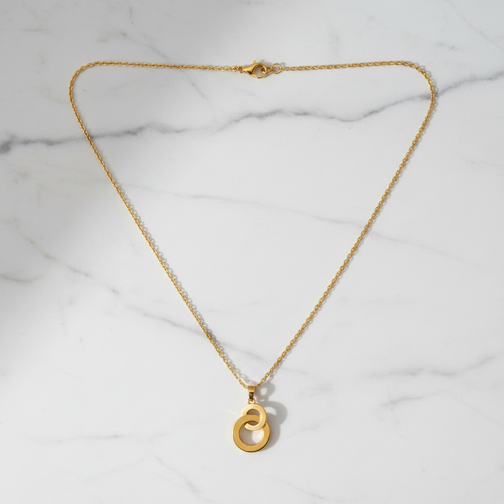 Gabon interlocking ring necklace flat lay on white marble