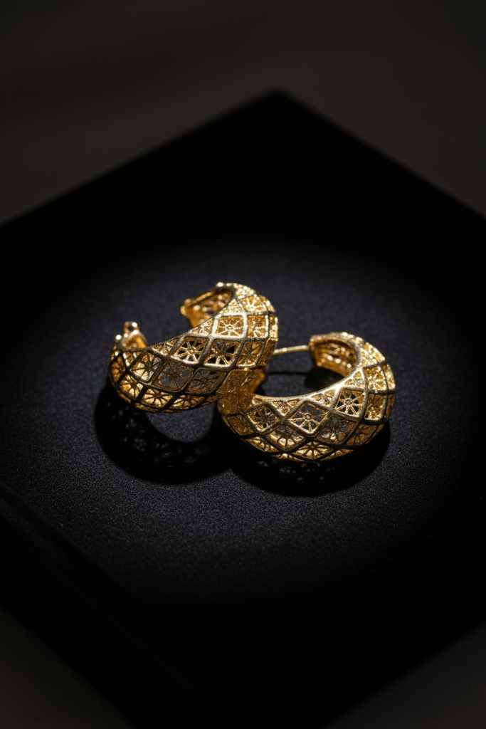 Ekow gold plated filigree semi hoop earrings on dark velvet jewelry tray