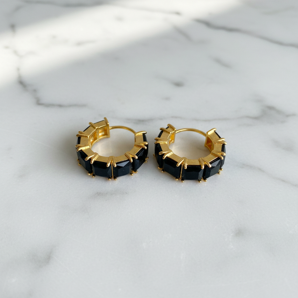Kennedy black stone huggie hoop earrings flat lay on white marble