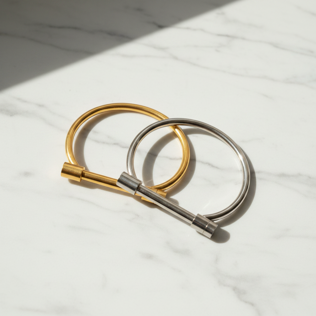 Kantuka bar bangle bracelet gold and silver flat lay on white marble