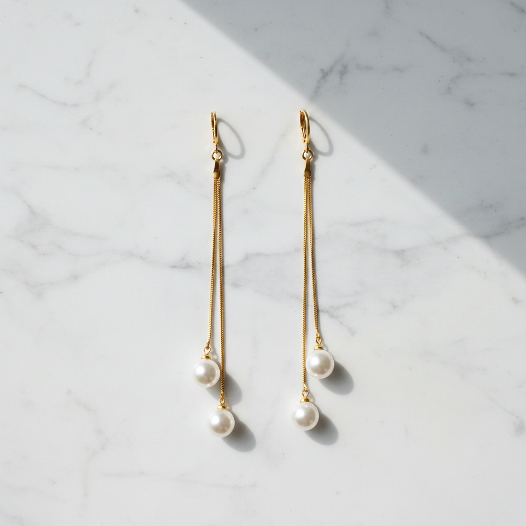 Olivia pearl drop earrings double gold chain flat lay on white marble