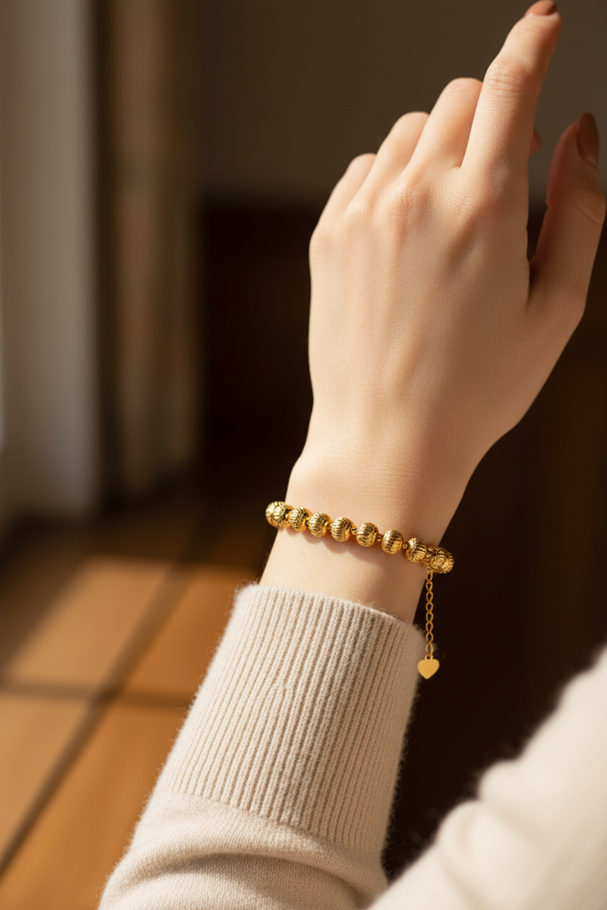 Eleanor gold diamond-cut ball bead bracelet on-wrist with heart charm