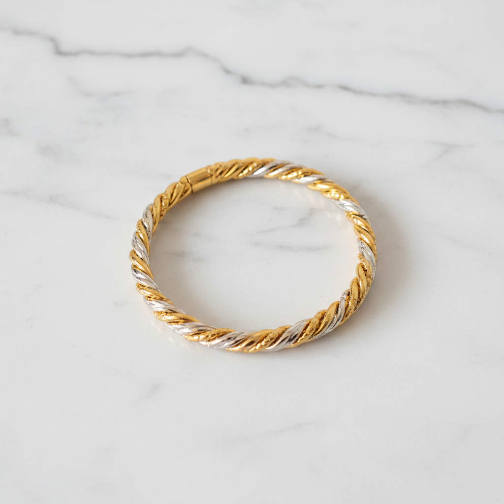 Capri two-tone twisted rope bangle bracelet flat lay on white marble