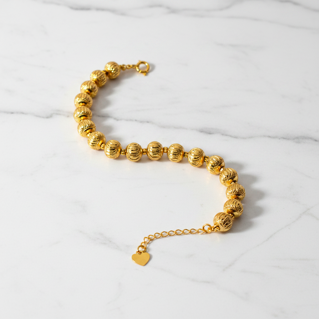 Eleanor gold diamond-cut ball bead bracelet flat lay on white marble