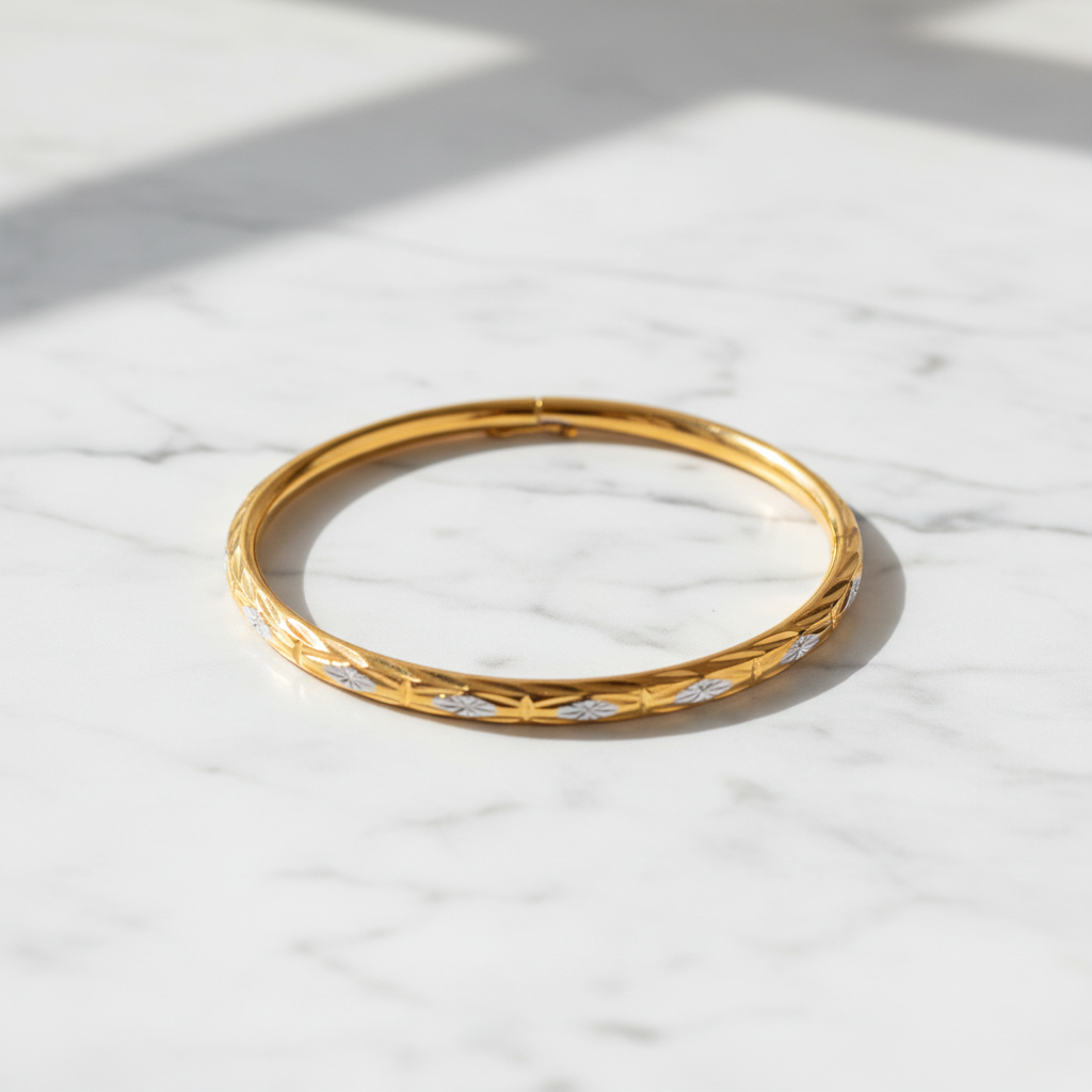 Doha two-tone gold bangle flat lay on white marble