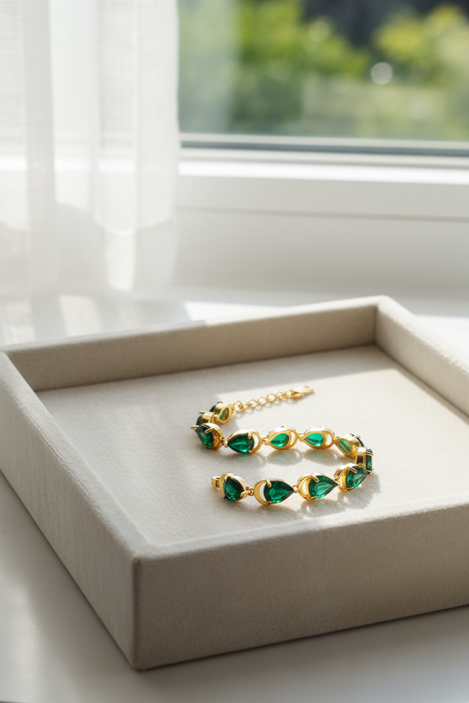 Adjua pear shape emerald tennis bracelet cream velvet tray display
