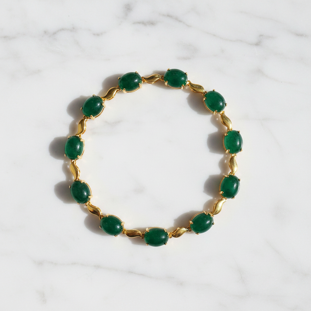 Halona cabochon emerald and gold bracelet flat lay on white marble