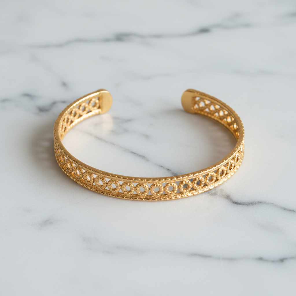 Isabella wide gold floral filigree open cuff bracelet flat lay on white marble
