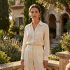Woman wearing petite gold filigree hoop earrings in an outdoor setting with soft sunlight, showcasing effortless elegance.