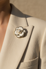 Ivory petal pearl bloom brooch pinned on cream blazer lapel