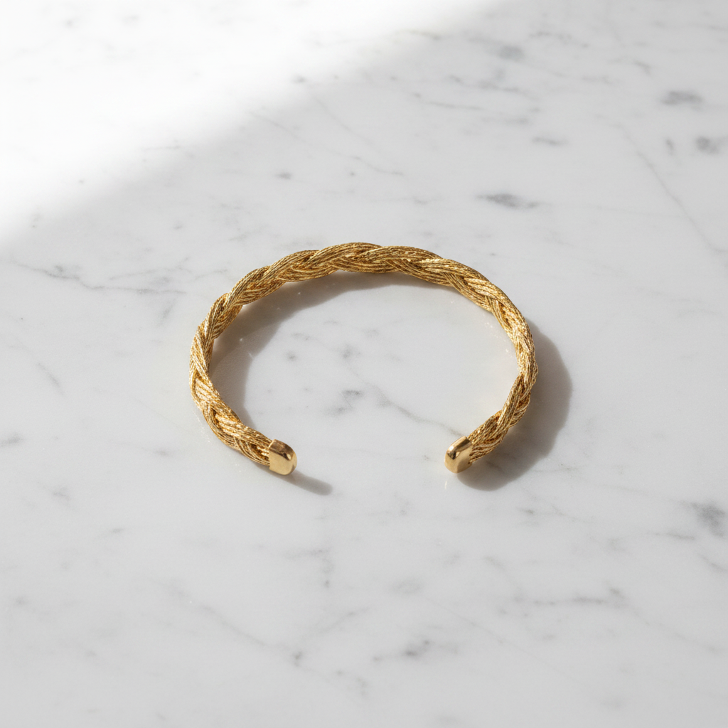 Dayo twist gold braided cuff bracelet flat lay on white marble