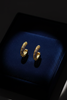 Esi gold plated filigree semi hoop earrings on dark velvet jewelry tray