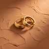 Geneva Gold Textured Hoop Earrings - flat lay terracotta ochre surface