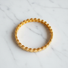 Ghana gold plated medallion bangle flat lay on white marble