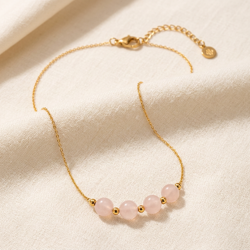 Orla pink three-bead necklace with gold-tone chain on cream linen