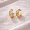 Ekow gold plated filigree semi hoop earrings flat lay on white linen