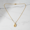 Gabon interlocking ring necklace flat lay on white marble