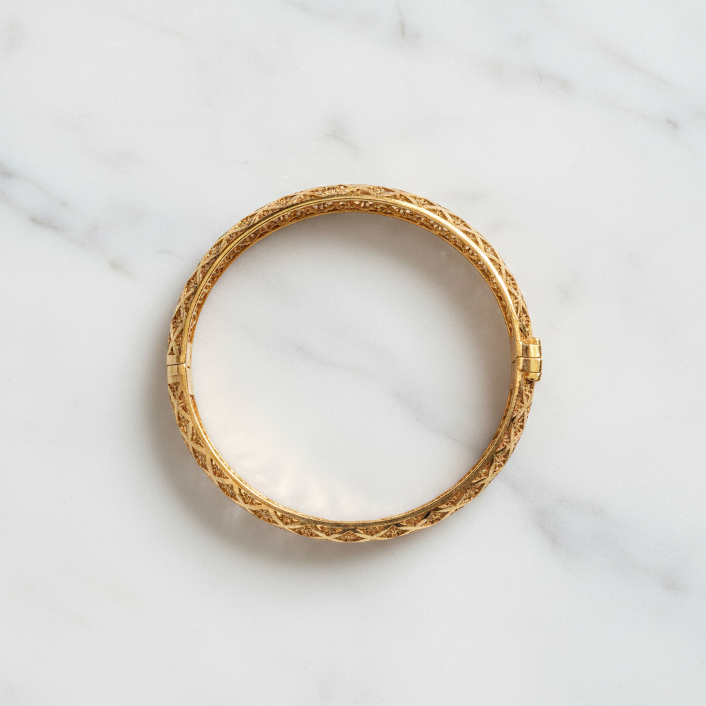 Riviera gold floral filigree bangle flat lay on white marble