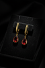 Amelia ruby red stone drop earrings on dark velvet tray