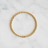 Langley slim closed gold twisted rope bangle flat lay on white marble