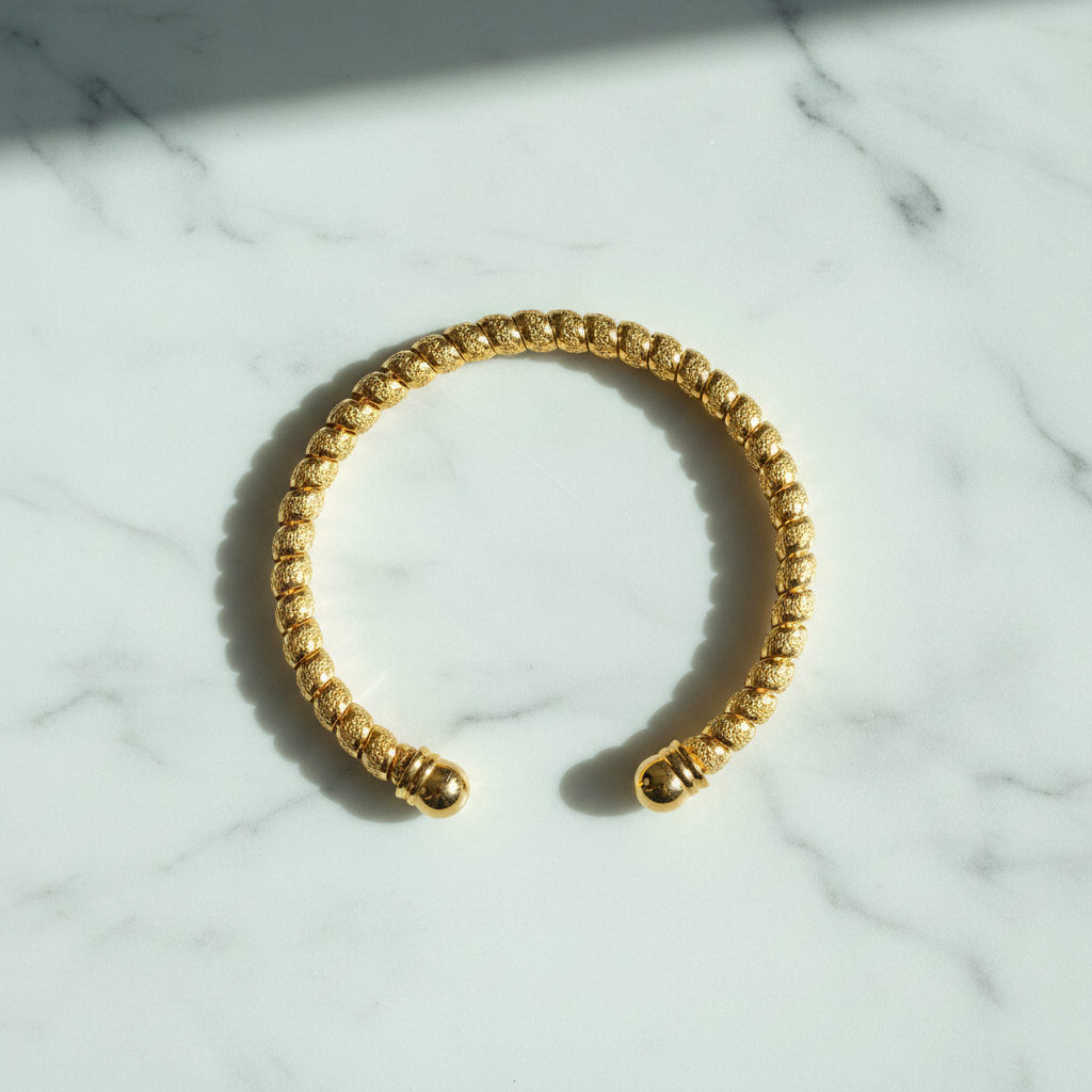 Liya textured beaded gold open cuff bracelet flat lay on white marble