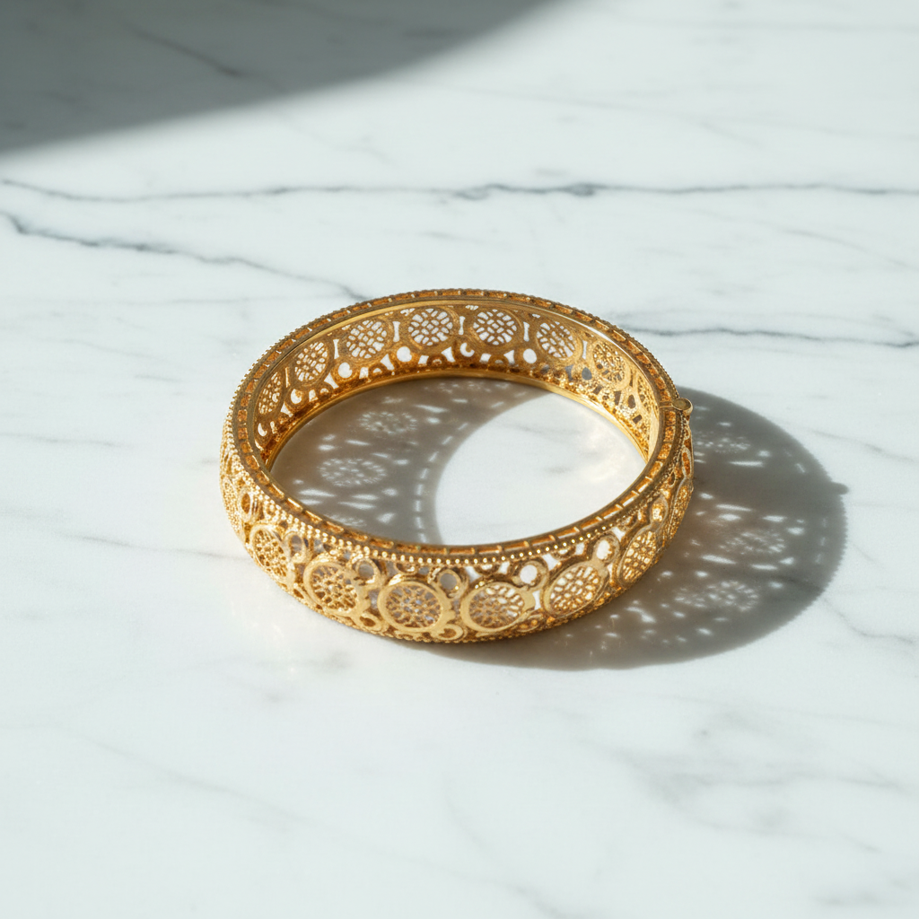 Minnie gold filigree bangle flat lay on white marble
