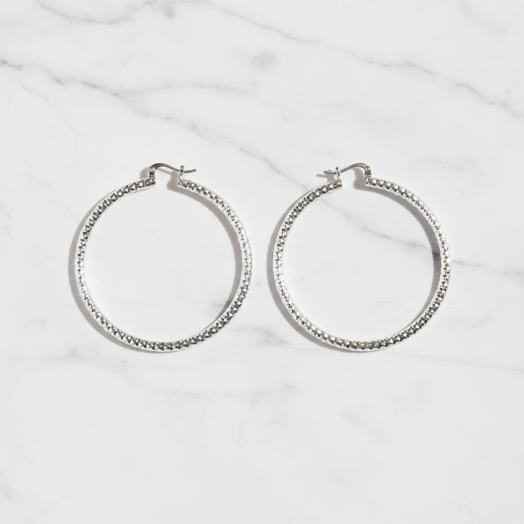 Citali white gold diamond-cut hoop earrings flat lay on white marble