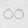 Citali white gold diamond-cut hoop earrings flat lay on white marble