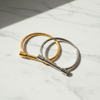 Kantuka bar bangle bracelet gold and silver flat lay on white marble