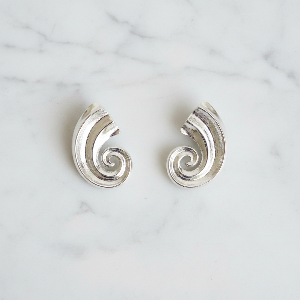 Kilgory silver swirl statement earrings flat lay on white marble