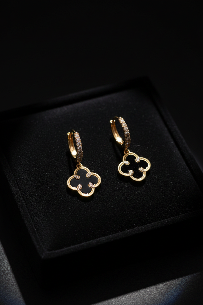 Madrid gold and black clover floral drop earrings on dark velvet jewelry tray