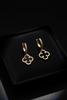 Madrid gold and black clover floral drop earrings on dark velvet jewelry tray