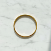 Anaya gold engraved bangle bracelet flat lay on white marble
