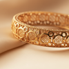 Minnie gold filigree bangle close-up openwork floral medallion detail
