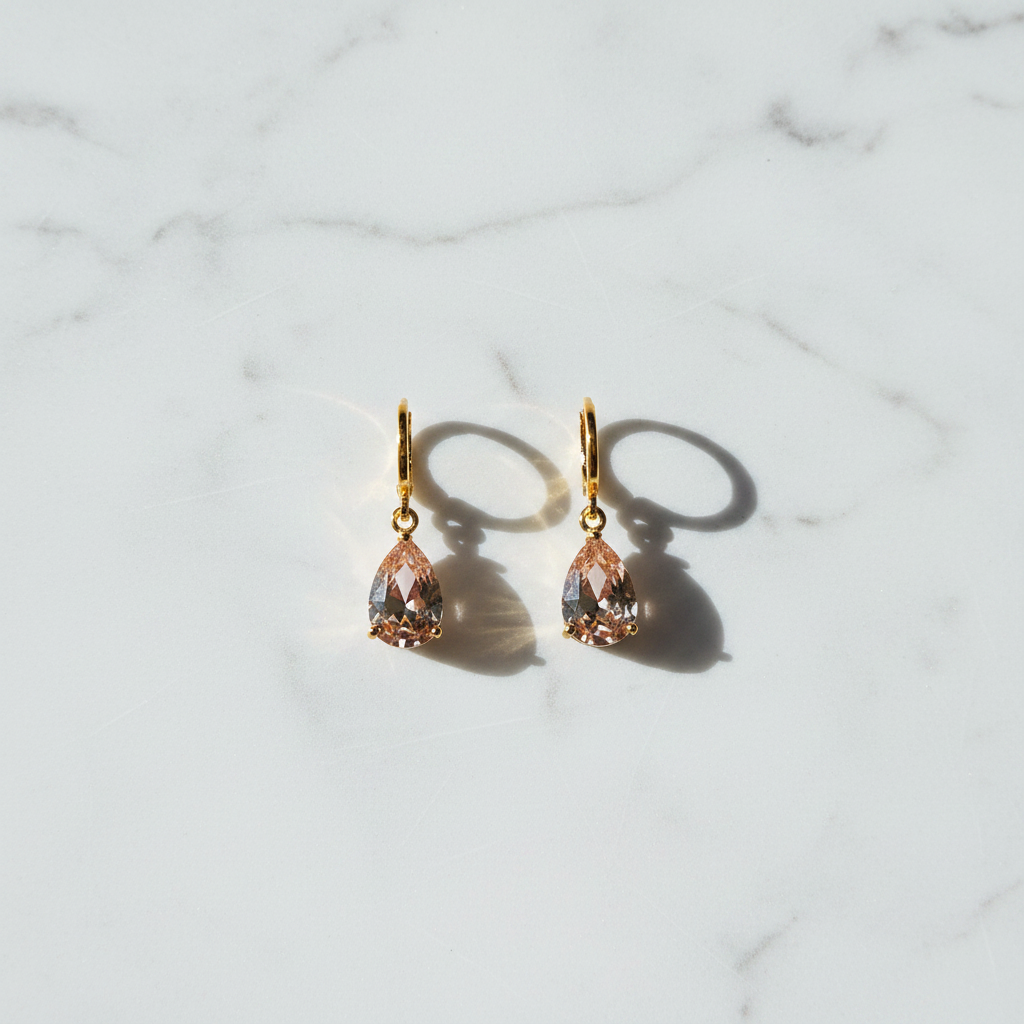 Rory champagne crystal teardrop drop earrings flat lay on white marble