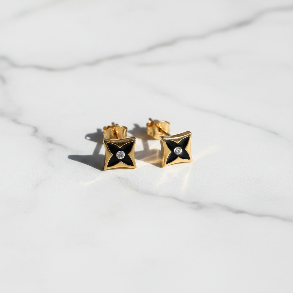 Lisbon gold and black star motif stud earrings flat lay on white marble