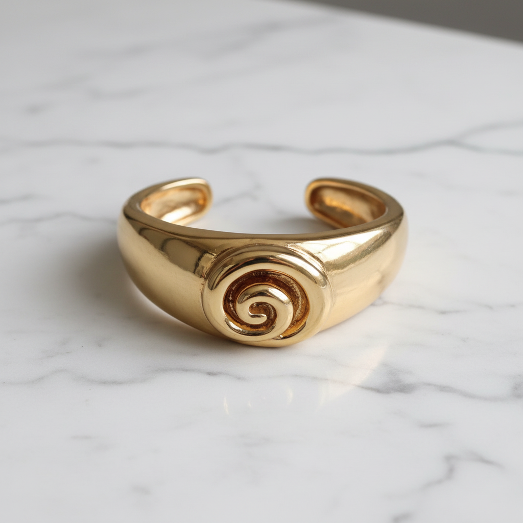 Isadora gold spiral cuff bracelet flat lay on white marble