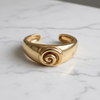 Isadora gold spiral cuff bracelet flat lay on white marble