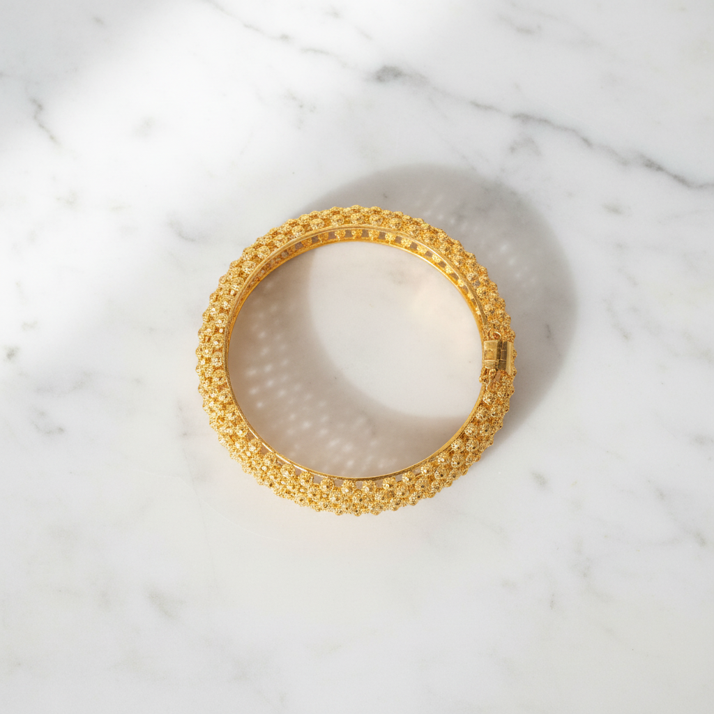 Alessia gold filigree lattice bangle bracelet flat lay on white marble