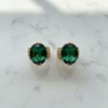 Marais emerald green oval gemstone huggie earrings flat lay on white marble
