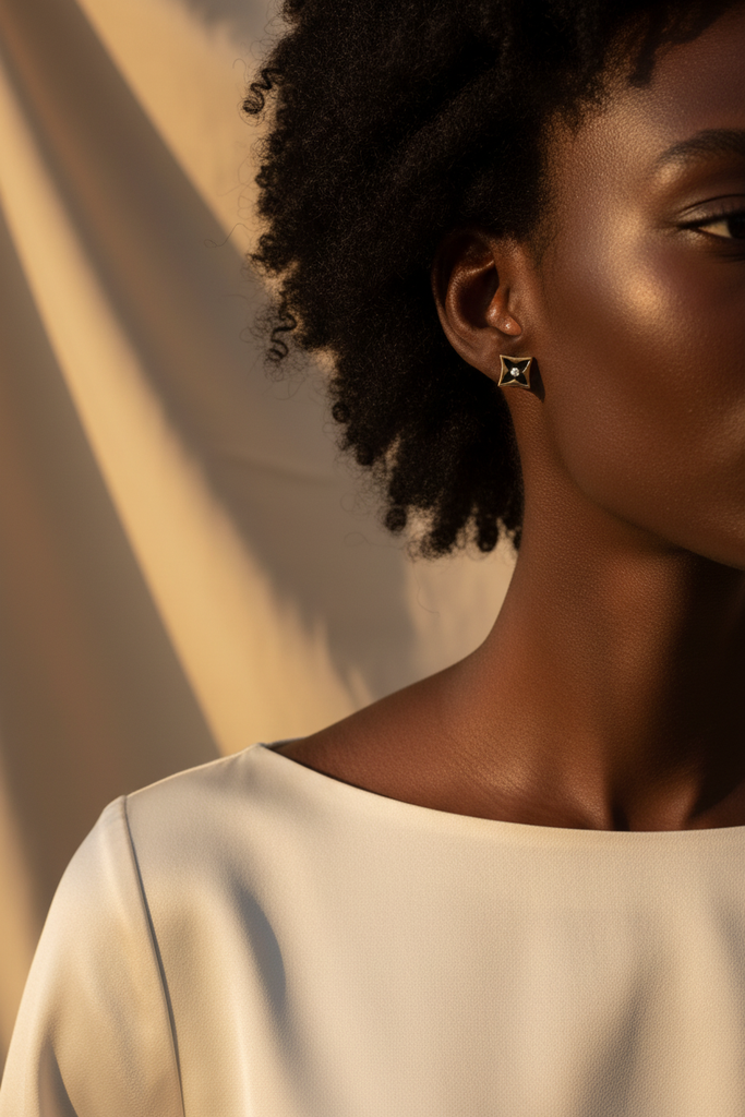 Lisbon gold and black star motif stud earrings worn on ear lifestyle shot