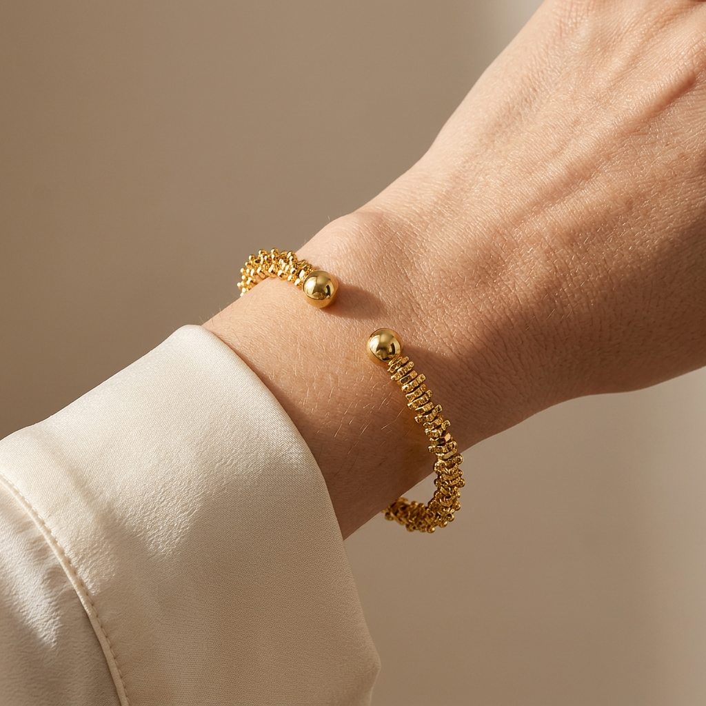 Carlisle gold-plated bracelet worn with a cream blouse