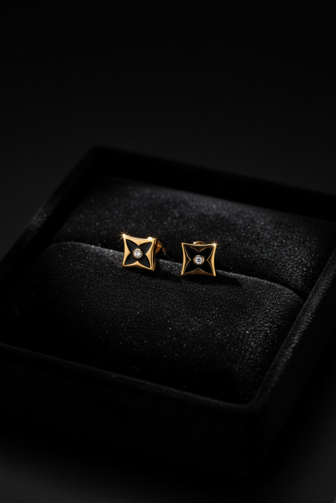 Lisbon gold and black stud earrings on dark velvet jewelry tray