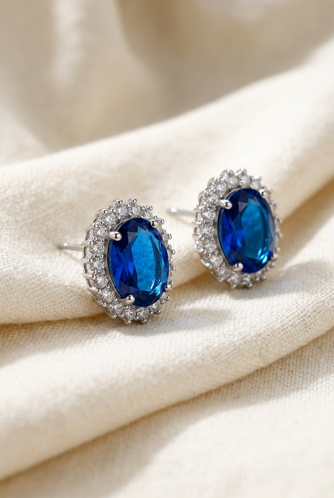 Vinan blue faux sapphire halo stud earrings on cream linen