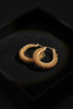 Monaco gold textured rope hoop earrings on dark velvet jewelry tray