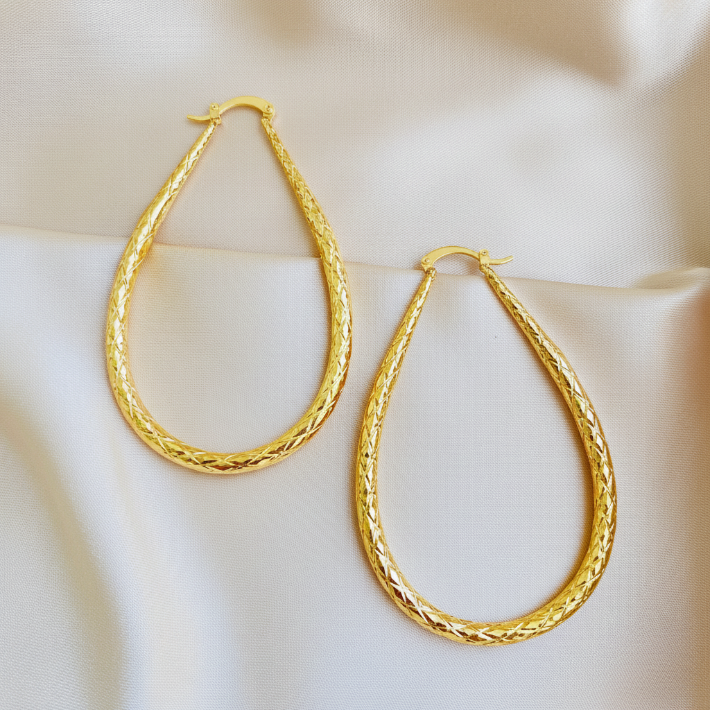 Bobbie gold oval hoop earrings flat lay on cream satin