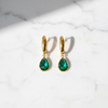 Amelia emerald green stone drop earrings flat lay on white marble