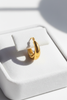 Dyani chunky gold crescent hoop earrings on white velvet jewelry tray
